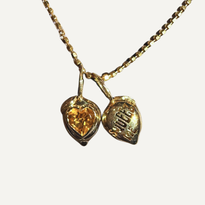 Gold necklace lemon shaped pendants with heart shaped citrine on a white background